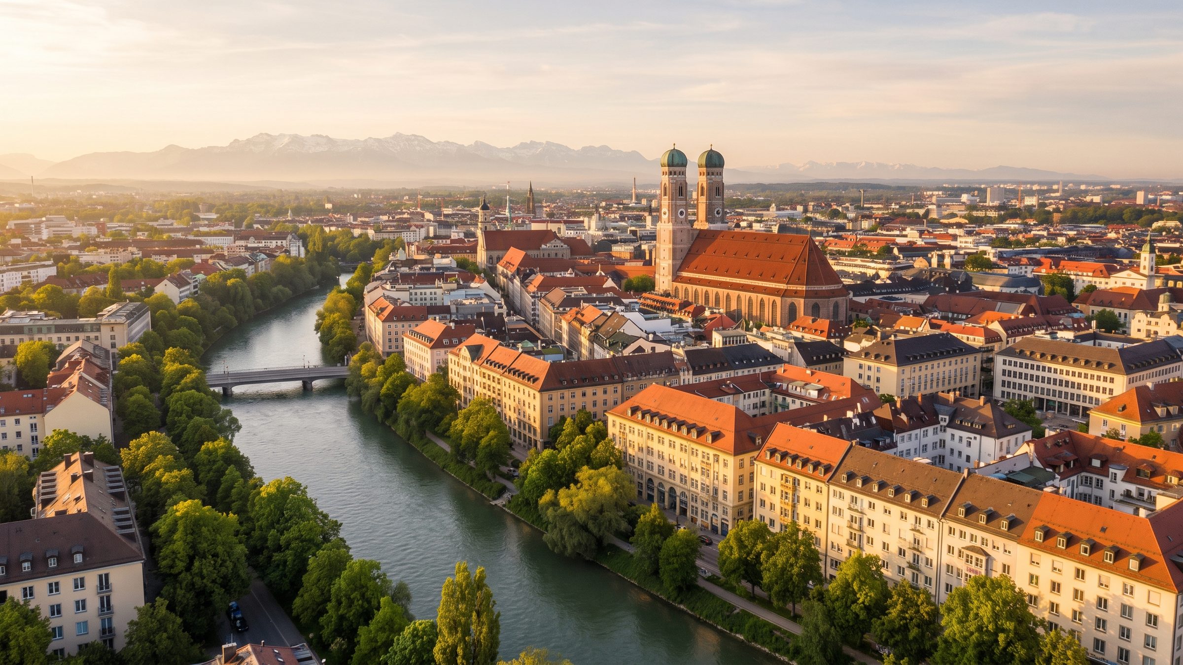 München im Abendlicht mit der Isar, der Frauenkirche und den Alpen am Horizont