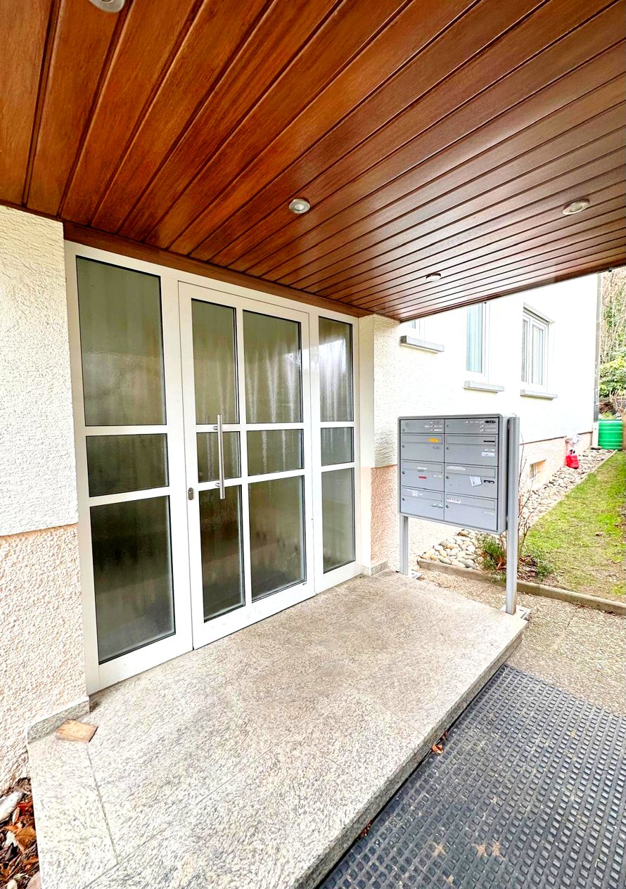 Hauseingang eines Mehrfamilienhauses in Baden-Baden mit Holzdecke und Briefkästen