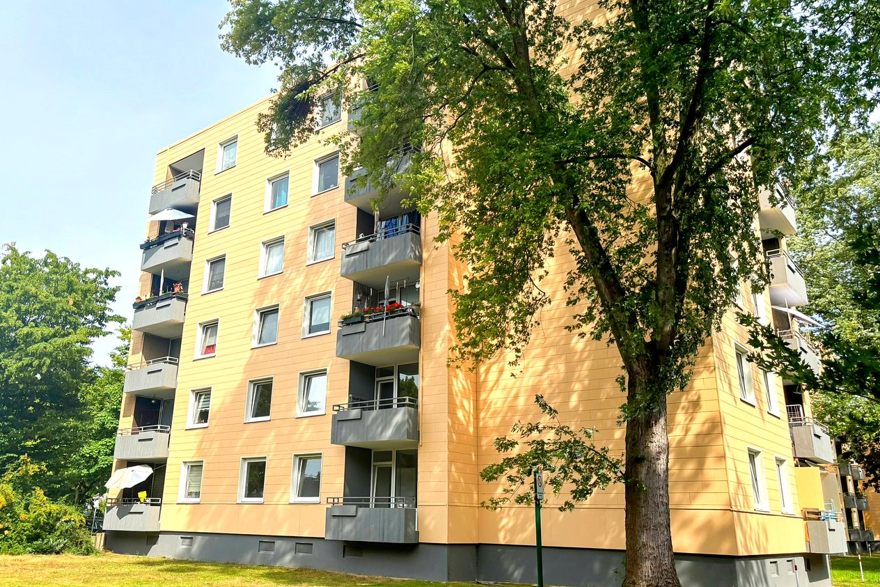 Mehrfamilienhaus in Düsseldorf mit Balkonen und großem Baum