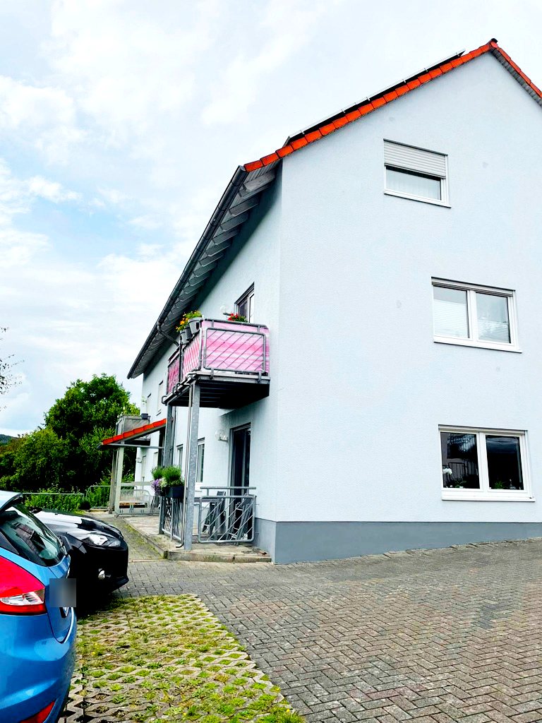 Weißes Mehrfamilienhaus in Heinzenhausen mit rotem Dach und Balkon