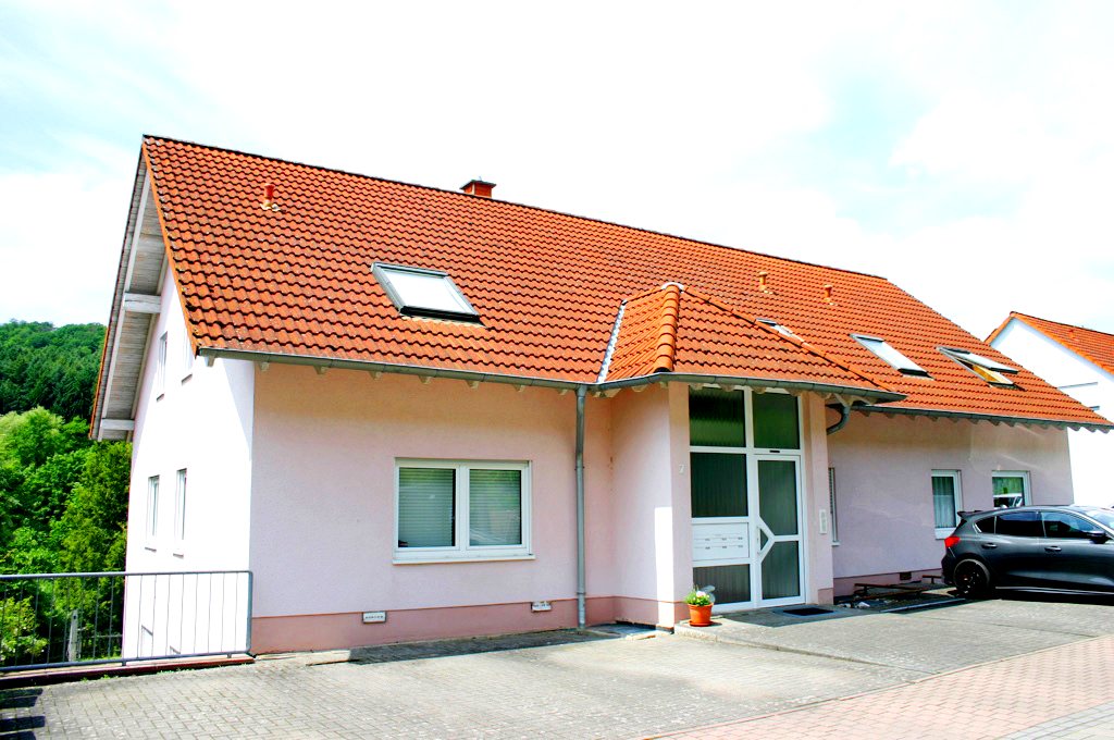 Mehrfamilienhaus in Heinzenhausen mit rotem Ziegeldach und Eingang