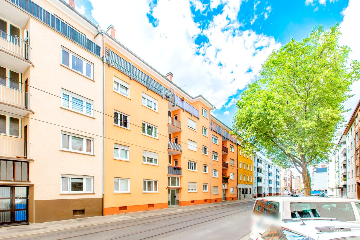 Mehrfamilienhäuser in Ludwigshafen an einer Straße mit großem Baum
