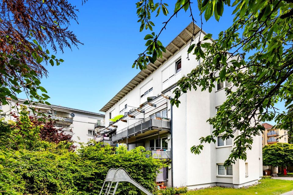 Weißes Mehrfamilienhaus in Rastatt mit Balkonen und Hecke