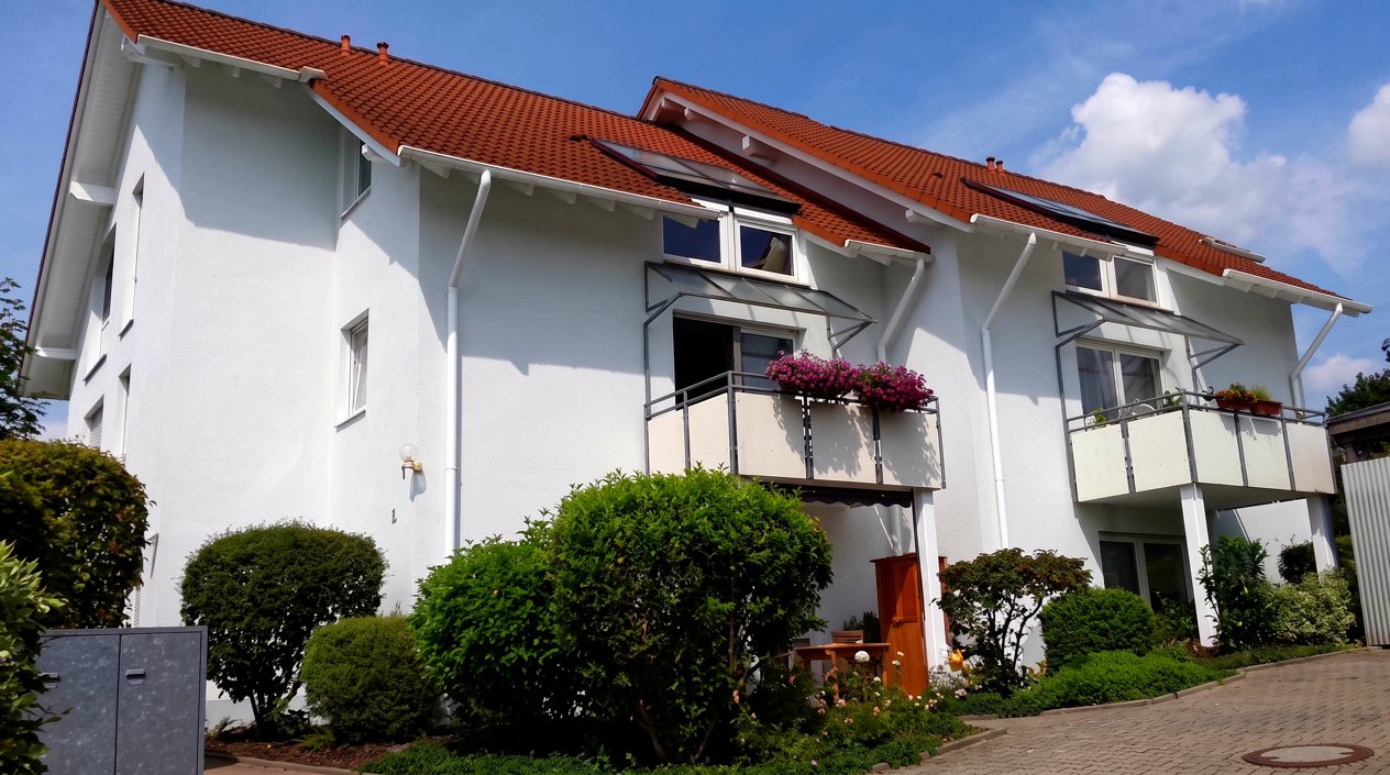 Mehrfamilienhaus in Rotenburg mit hellem Putz und rotem Ziegeldach
